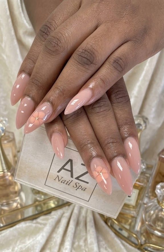 Nude almond nails with delicate floral accent